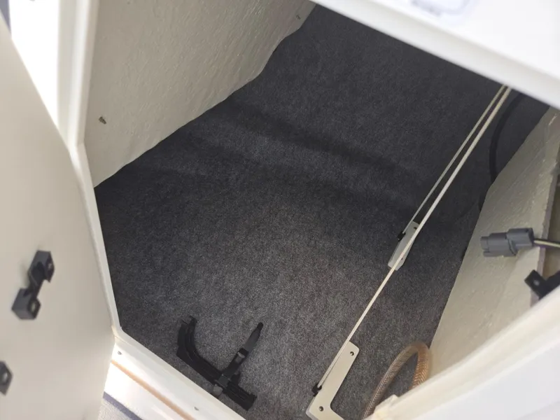 Slide: The Image of 2021 Yamaha Boats SX195 storage compartment with carpeted interior. - 17