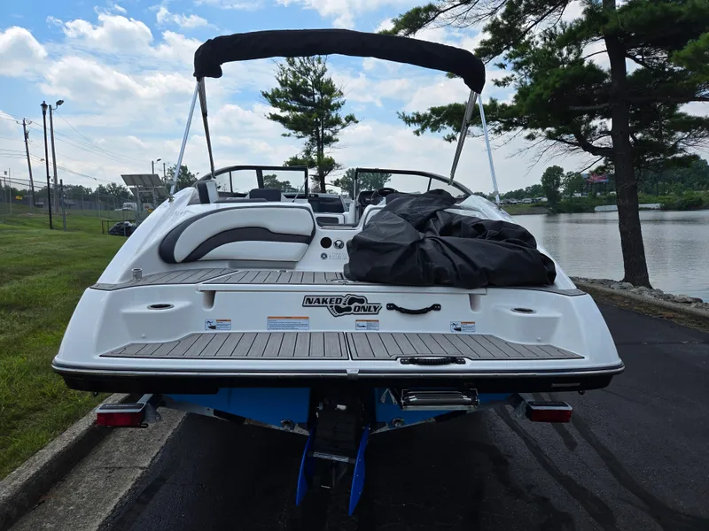 Slide: The Image of 2021 Yamaha Boats SX195 on trailer by lakeside, under a cloudy sky. - 2
