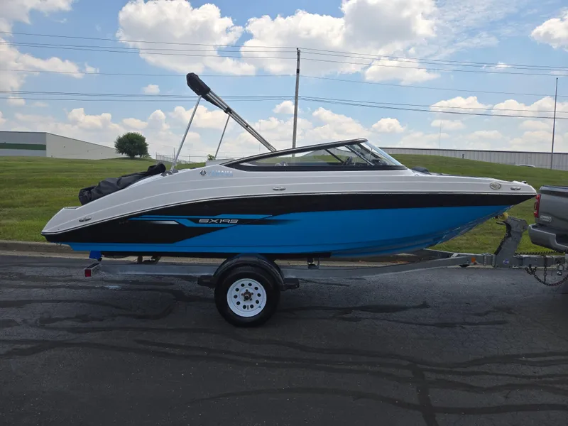 Slide: The Image of 2021 Yamaha Boats SX195 on trailer, parked outdoors under a cloudy sky. - 4