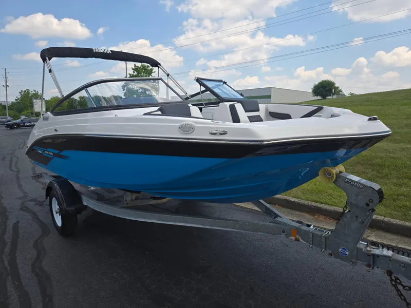 Slide: The Image of 2021 Yamaha Boats SX195 on trailer, blue and white design, parked outdoors. - 5