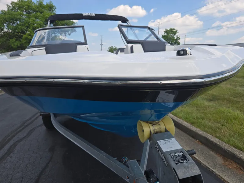 Slide: The Image of 2021 Yamaha Boats SX195 on trailer, parked outdoors, showcasing sleek design and vibrant blue hull. - 6