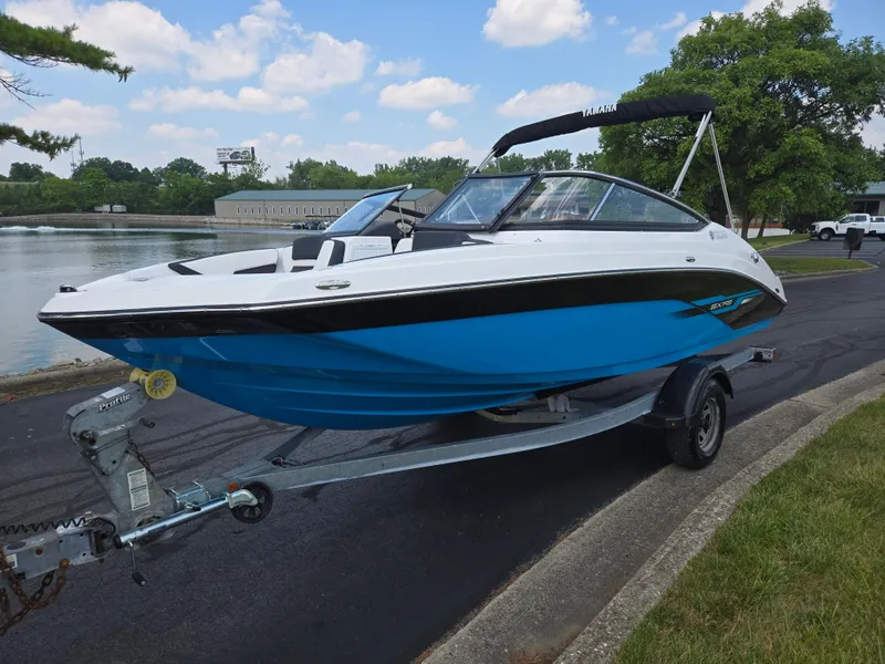 Slide: The Image of 2021 Yamaha Boats SX195 on trailer by a lake, under a clear sky. - 8