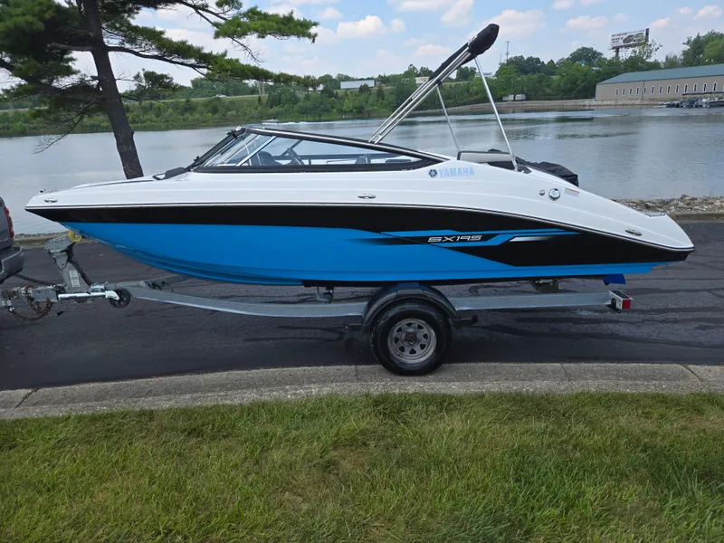 Slide: The Image of 2021 Yamaha Boats SX195 on trailer by a lakeside, showcasing sleek design and vibrant colors. - 9