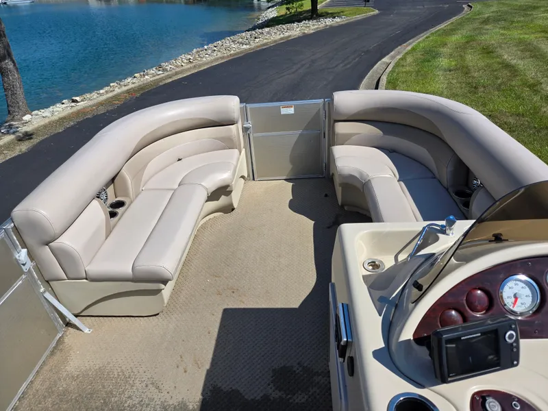 Slide: The Image of 2013 Starcraft Stardeck 190 Cruise pontoon boat interior with beige seating and control panel. - 13