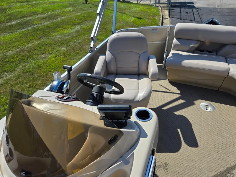 Slide: The Image of 2013 Starcraft Stardeck 190 Cruise interior with beige seating and steering console. - 16