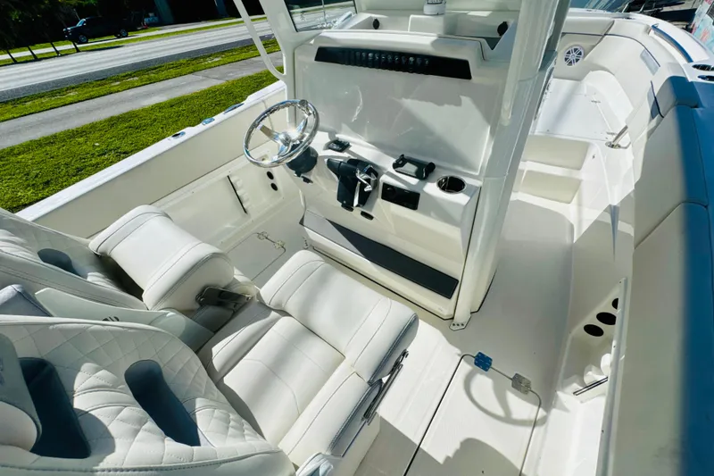 Slide: The Image of 2026 Sailfish 252 CC boat interior with white seating and modern helm controls. - 10