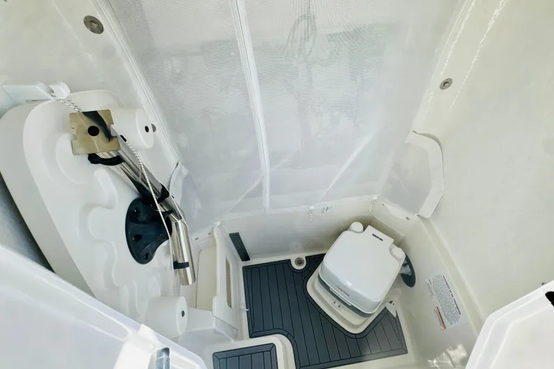 Slide: The Image of Interior of 2026 Sailfish 252 CC boat featuring compact marine toilet setup. - 17