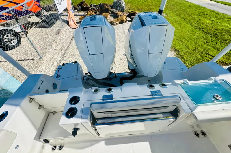 Slide: The Image of 2026 Sailfish 252 CC boat with dual Mercury outboard engines, docked on gravel. - 5