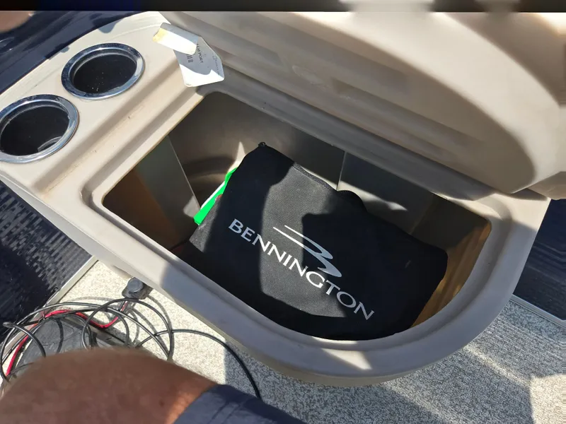 Slide: The Image of Open storage compartment in a 2019 Bennington 188 SFV boat with cup holders. - 21