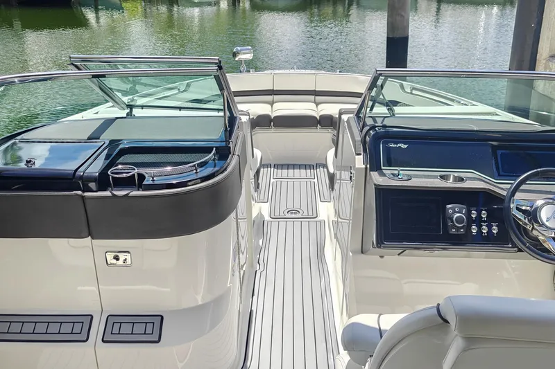 Slide: The Image of 2018 Sea Ray SLX 310 boat interior with open storage compartment and refrigerator. - 16