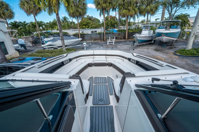 Slide: The Image of 2018 Sea Ray SLX 310 boat with spacious seating, docked near palm trees. - 23