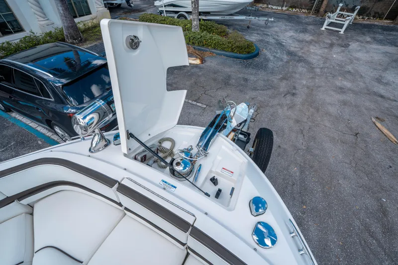 Slide: The Image of 2018 Sea Ray SLX 310 boat with open storage compartment, parked near a black car. - 27