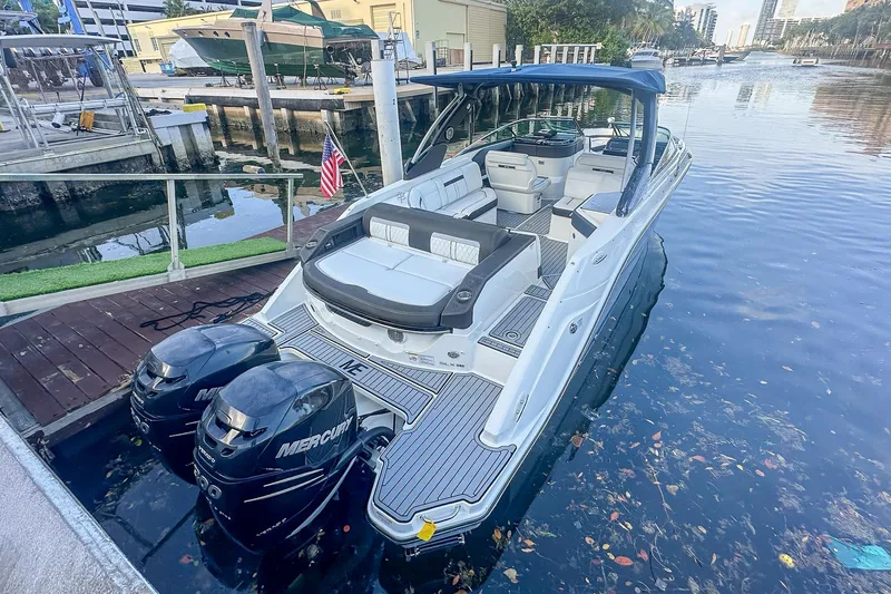 Slide: The Image of 2018 Sea Ray SLX 310 boat with dual 300 horsepower engines, parked near palm trees. - 3