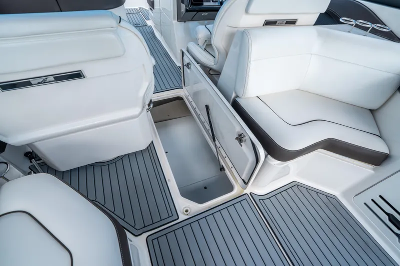 Slide: The Image of 2018 Sea Ray SLX 310 boat interior with open storage compartment and white seating. - 30