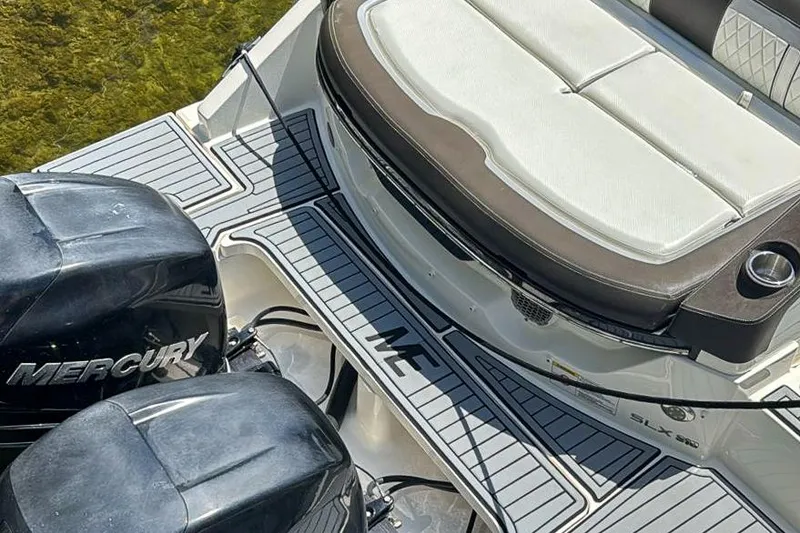 Slide: The Image of 2018 Sea Ray SLX 310 boat on trailer in a sunny marina setting. - 7