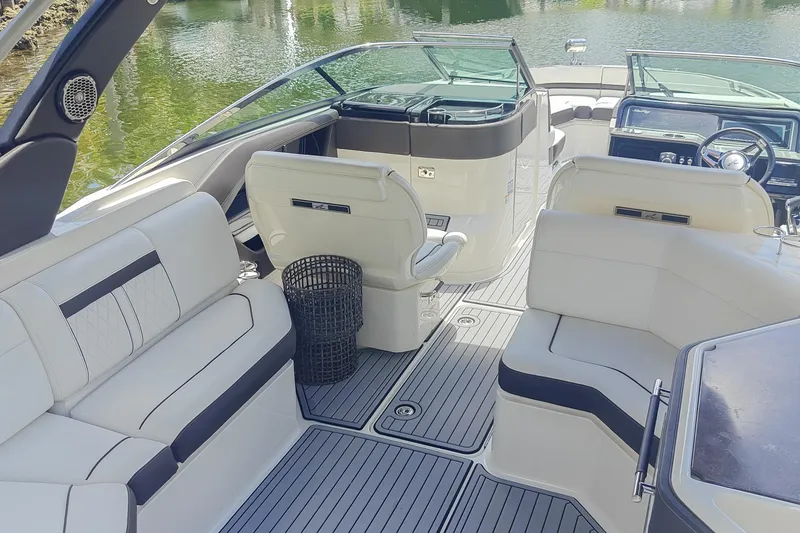 Slide: The Image of 2018 Sea Ray SLX 310 boat interior with luxurious seating and canopy, surrounded by palm trees. - 9