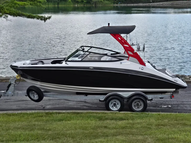 The Image of 2018 Yamaha Boats 212X on trailer by a serene lake. - 0