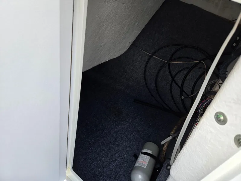 Slide: The Image of Interior storage compartment of a 2018 Yamaha Boats 212X, featuring cables and equipment. - 15