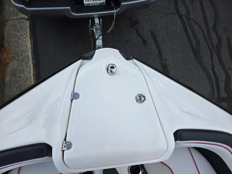 Slide: The Image of 2018 Yamaha Boats 212X bow view, featuring sleek white design and trailer connection. - 18