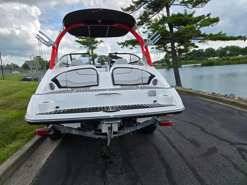 Slide: The Image of 2018 Yamaha Boats 212X on trailer by a lake, showcasing sleek design and features. - 2