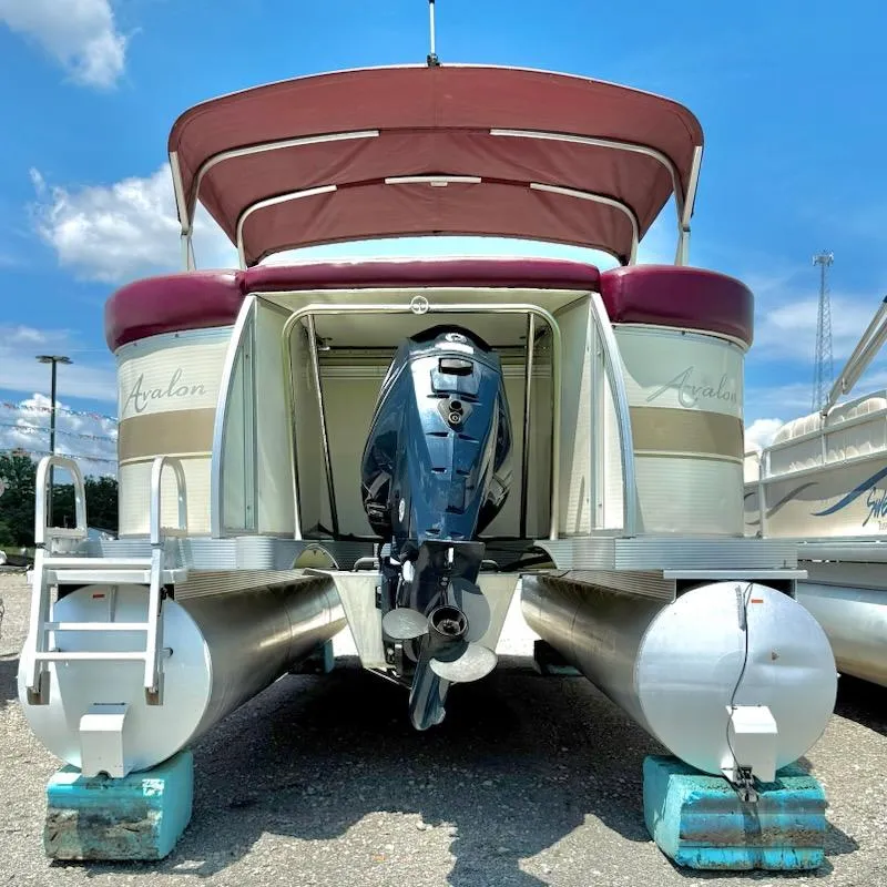 Slide: The Image of 2005 Avalon EXCALIBER 2325 pontoon boat with outboard motor, parked on blocks. - 3