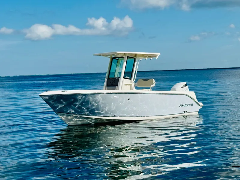 Slide: The Image of 2026 Sailfish 232 CC boat on calm ocean waters under a clear blue sky. - 1