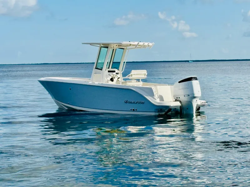Slide: The Image of 2026 Sailfish 232 CC boat on calm ocean waters under blue sky. - 2