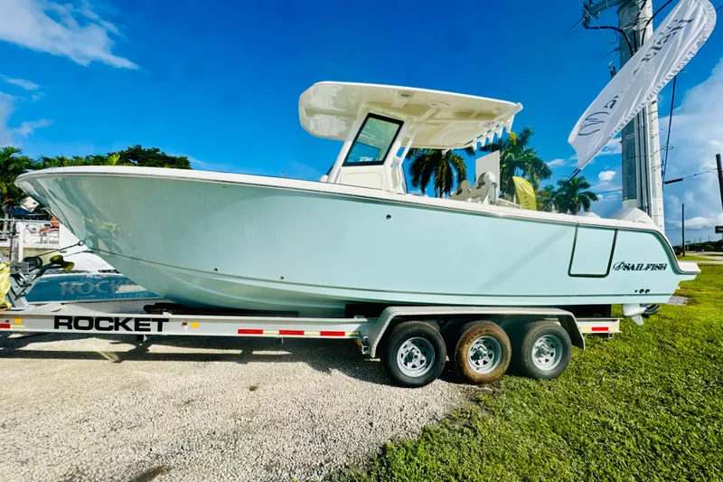 The Image of 2026 Sailfish 272 CC boat on trailer, displayed outdoors under clear blue sky. - 0