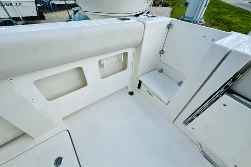 Slide: The Image of 2026 Sailfish 272 CC boat interior, featuring sleek white seating and storage compartments. - 10
