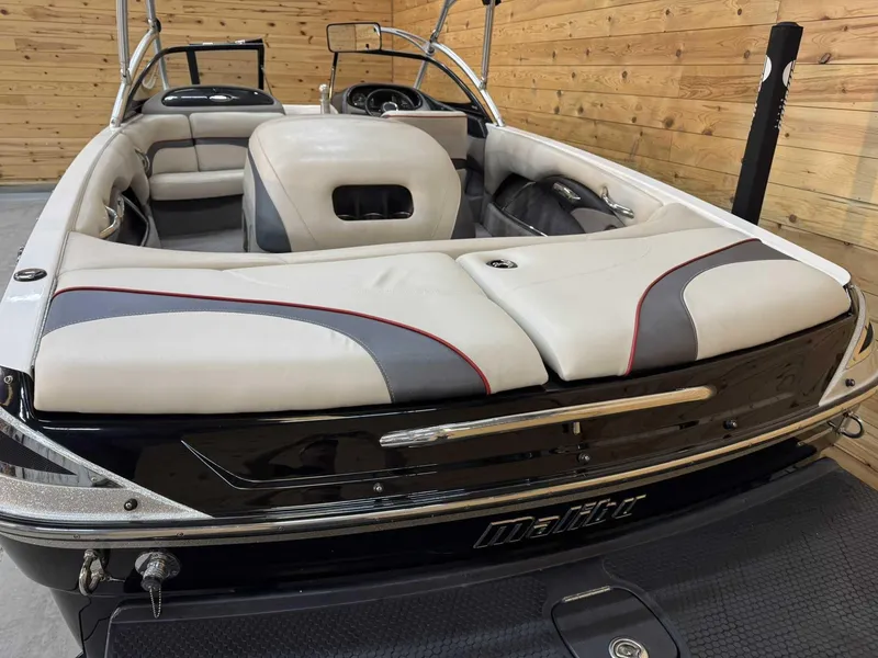 Slide: The Image of 2013 Malibu Response TXi Open Bow boat interior with sleek seating and wood paneling. - 3