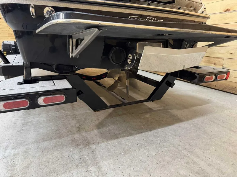 Slide: The Image of 2013 Malibu Response TXi Open Bow boat rear view, showcasing propeller and trailer details. - 4