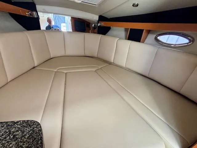 Slide: The Image of 2010 Chaparral Signature 270 cabin interior with beige seating and porthole window. - 11