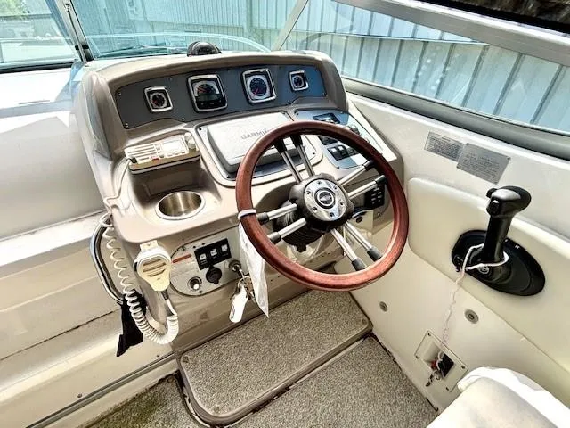Slide: The Image of 2010 Chaparral Signature 270 boat helm with wooden steering wheel and control panel. - 15