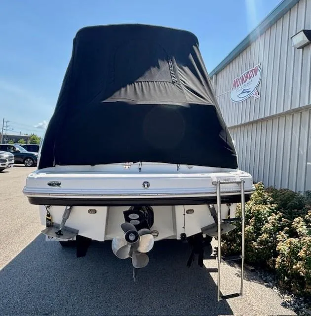 Slide: The Image of 2010 Chaparral Signature 270 boat with black cover, parked near a building. - 18