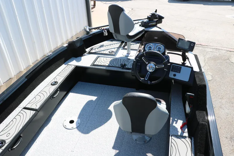 Slide: The Image of 2025 Smoker Craft Excursion 166 SC boat interior with steering wheel and seating. - 13