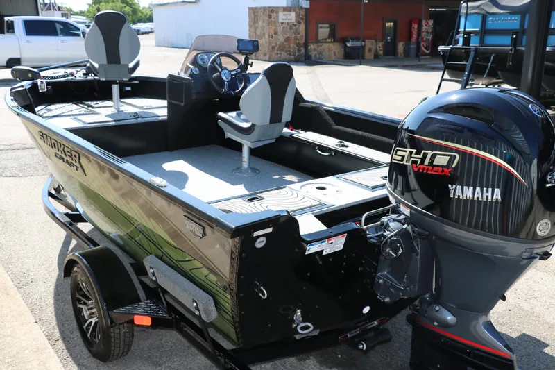 Slide: The Image of 2025 Smoker Craft Excursion 166 SC boat with Yamaha engine, parked outdoors. - 7