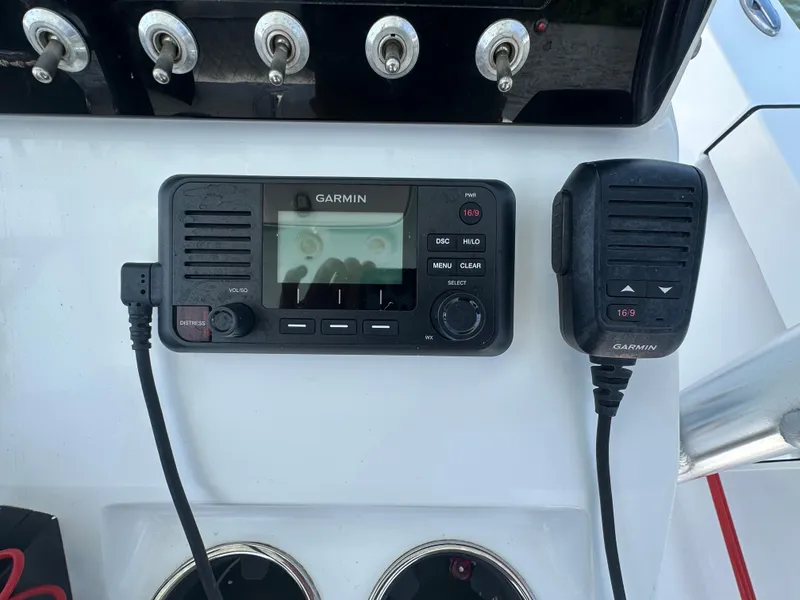 Slide: The Image of Garmin marine radio and microphone on 2021 Sportsman Masters 227 Bay Boat dashboard. - 12
