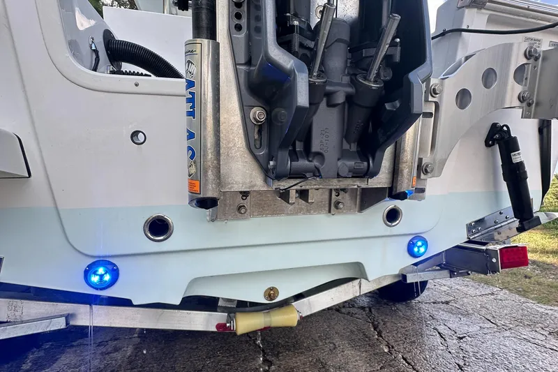 Slide: The Image of 2021 Sportsman Masters 227 Bay Boat transom with blue LED lights and hydraulic components. - 18