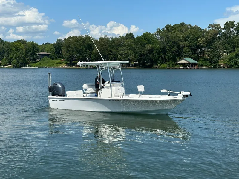 Slide: The Image of 2021 Sportsman Masters 227 Bay Boat on a serene lake with lush green shoreline. - 3