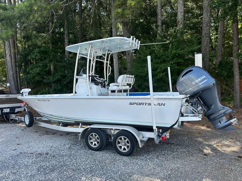 Slide: The Image of 2021 Sportsman Masters 227 Bay Boat on trailer, parked in wooded area. - 4