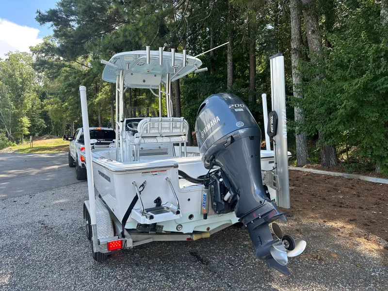 Slide: The Image of 2021 Sportsman Masters 227 Bay Boat on trailer, Yamaha outboard, parked near forested area. - 6