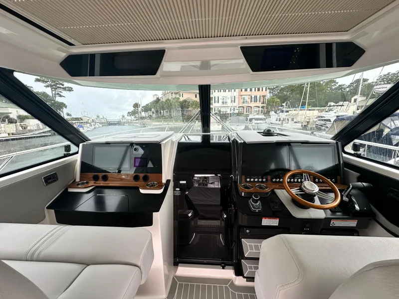 Slide: The Image of Interior view of 2023 Tiara Yachts 43 LE helm with modern controls and navigation systems. - 17