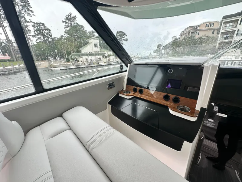 Slide: The Image of 2023 Tiara Yachts 43 LE interior with modern dashboard and waterfront view. - 18