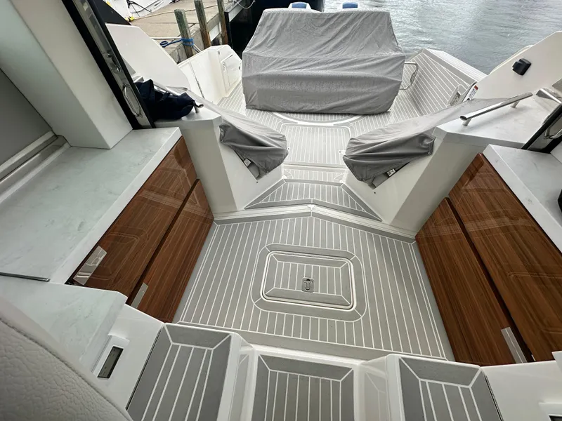 Slide: The Image of 2023 Tiara Yachts 43 LE deck with sleek wood accents and covered seating area. - 23