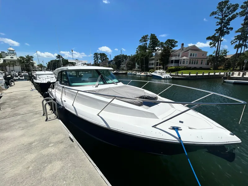 Slide: The Image of 2023 Tiara Yachts 43 LE docked at a marina under a clear blue sky. - 3