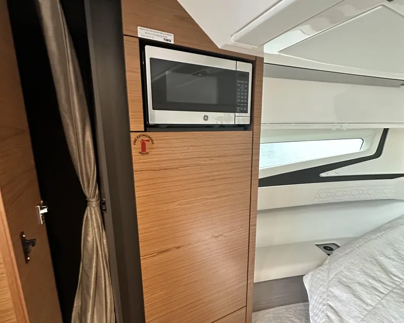 Slide: The Image of 2023 Tiara Yachts 43 LE interior with microwave and modern wood paneling. - 37