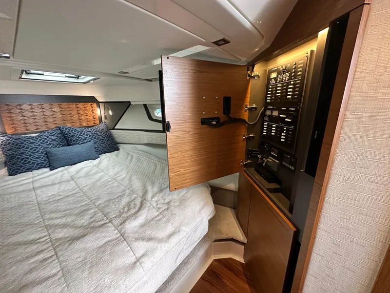 Slide: The Image of 2023 Tiara Yachts 43 LE cabin interior with bed and open control panel. - 41