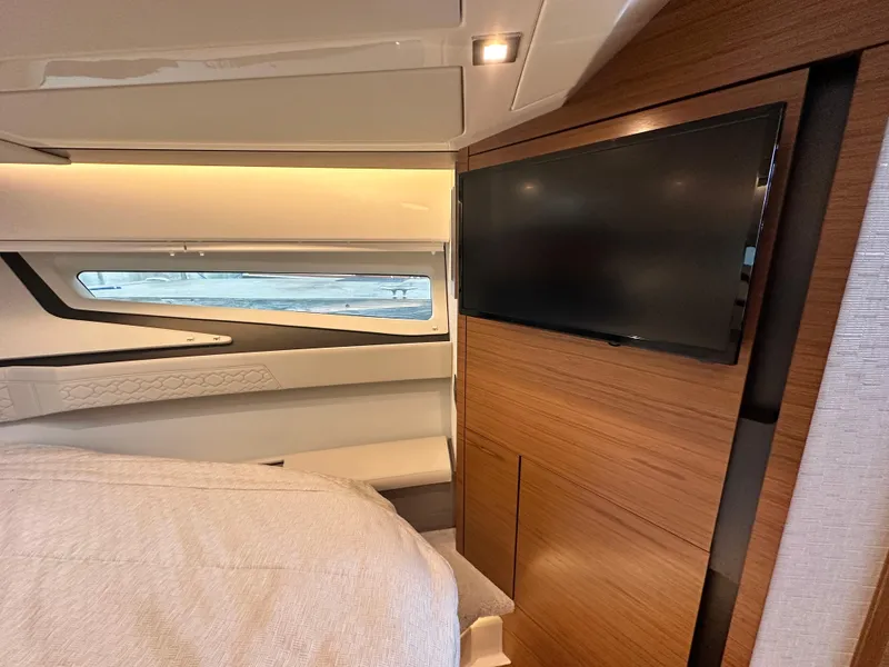 Slide: The Image of Luxurious interior of 2023 Tiara Yachts 43 LE with modern TV and sleek wood paneling. - 44