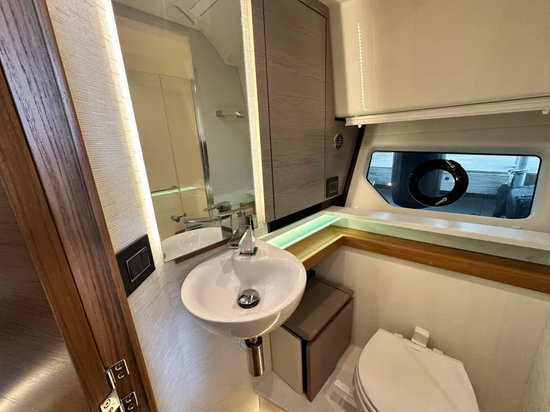 Slide: The Image of 2023 Tiara Yachts 43 LE bathroom with modern sink, mirror, and window. - 47