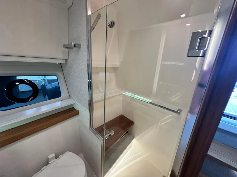 Slide: The Image of 2023 Tiara Yachts 43 LE bathroom with modern shower and porthole window. - 48